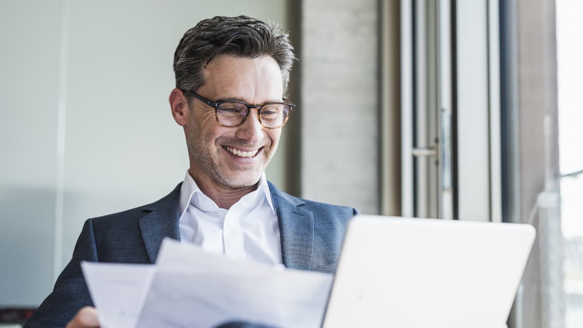 man smiling in front of laptop